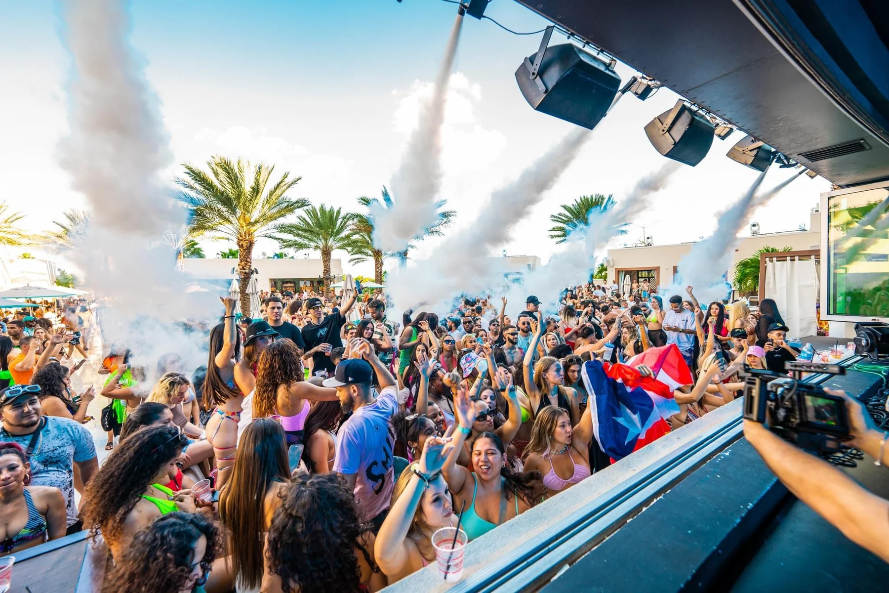 Large crowd with hands up under CO2 cannons at DAER Dayclub